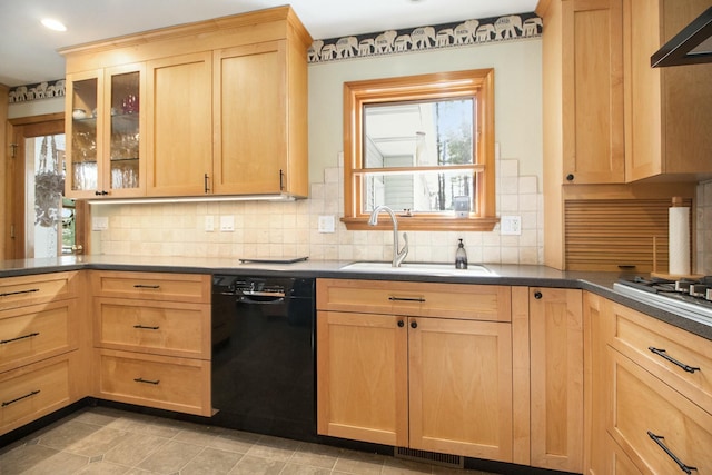 kitchen with black dishwasher, dark countertops, glass insert cabinets, under cabinet range hood, and a sink