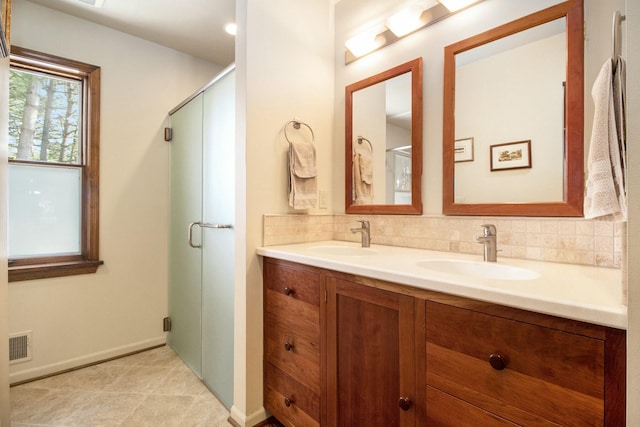 bathroom featuring double vanity, tasteful backsplash, visible vents, and a sink