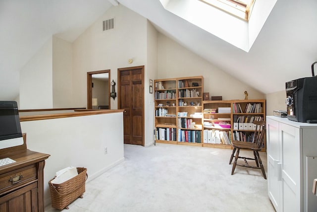 home office featuring vaulted ceiling with skylight, light colored carpet, and visible vents