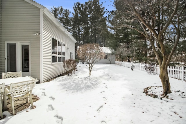 snowy yard featuring fence