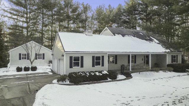 view of front of house with a garage, covered porch, and a chimney