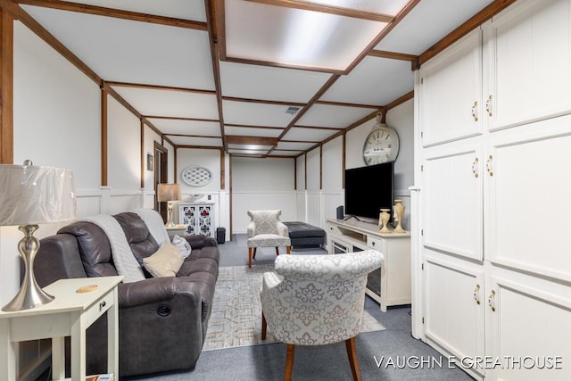 living room featuring a wainscoted wall, a decorative wall, and carpet flooring