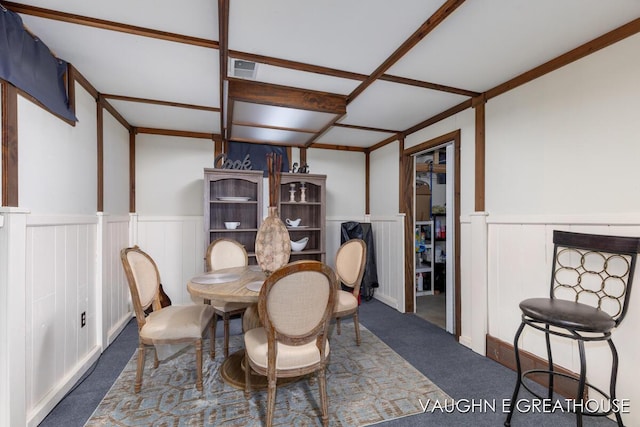 carpeted dining space featuring visible vents and wainscoting