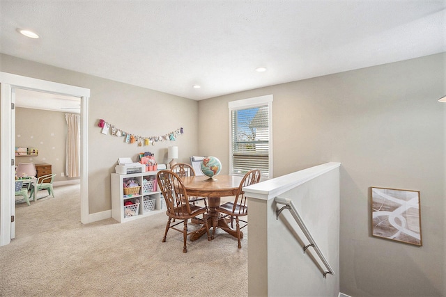 dining room with recessed lighting, light carpet, and baseboards