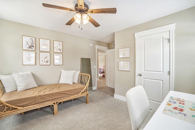 office space featuring ceiling fan, baseboards, and light colored carpet