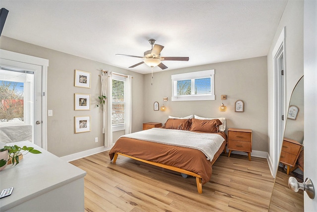 bedroom with baseboards, a ceiling fan, and light wood-style floors