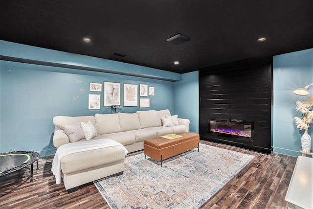 living area with visible vents, a fireplace, baseboards, and dark wood finished floors