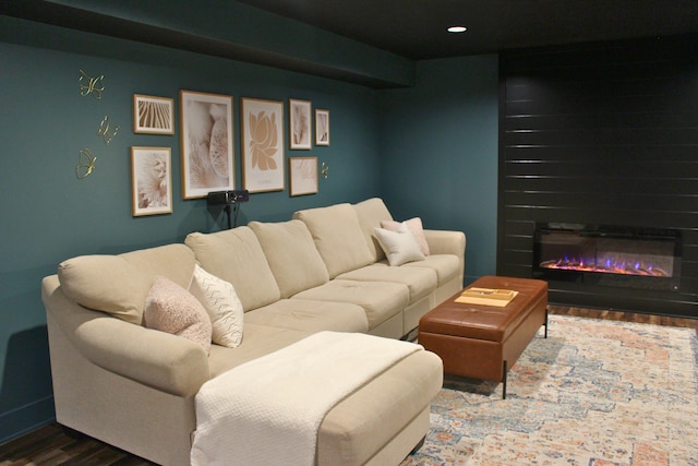 living area with a glass covered fireplace and wood finished floors