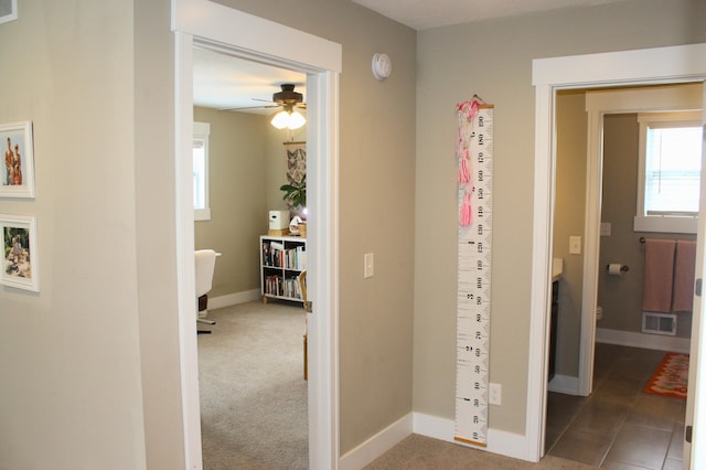 hallway with carpet, baseboards, and visible vents