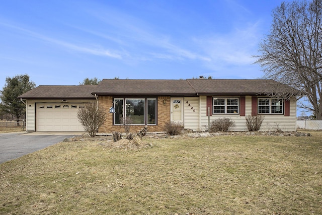 ranch-style house with a garage, aphalt driveway, a front lawn, and brick siding