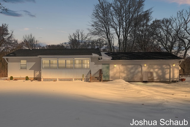 rear view of property with a garage and concrete driveway