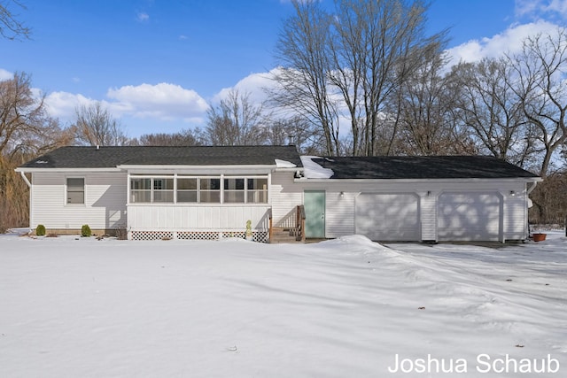 snow covered house featuring a sunroom