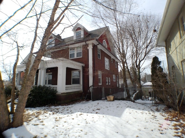 view of front of house with a garage, brick siding, and fence