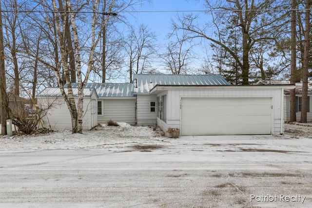 view of front of house featuring a garage, metal roof, and board and batten siding