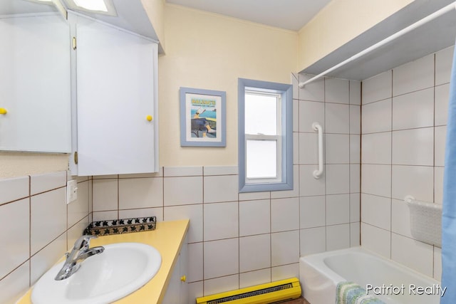 full bathroom featuring a baseboard heating unit, tile walls, vanity, and shower / bathtub combination