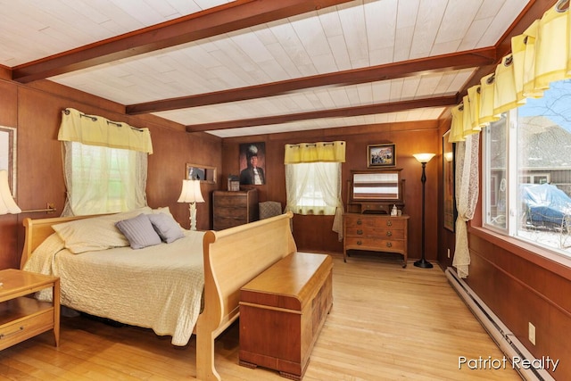 bedroom with a baseboard heating unit, beam ceiling, light wood-style floors, and wooden walls