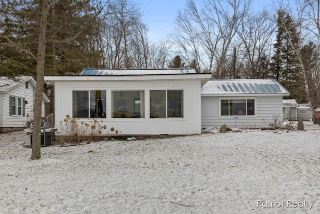 rear view of house featuring metal roof