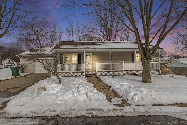 view of front facade with a porch, an attached garage, and aphalt driveway