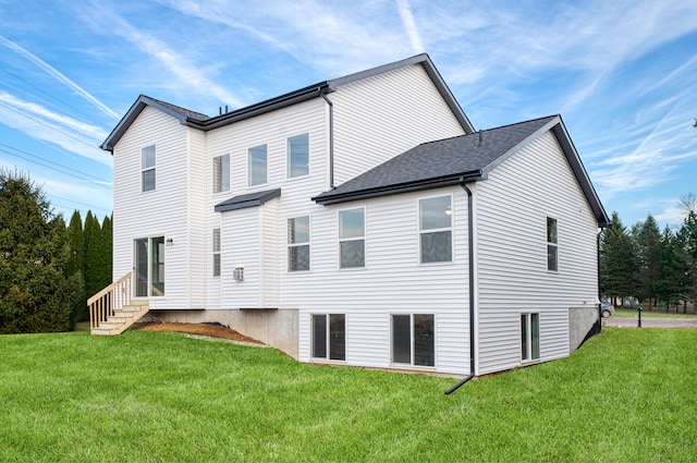 rear view of property with entry steps and a yard