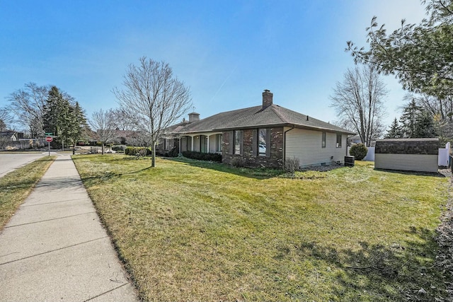 view of home's exterior with brick siding, a lawn, a chimney, and an outdoor structure