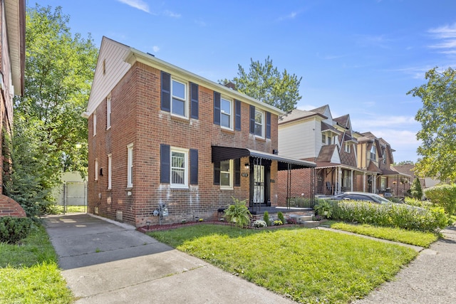 view of front facade featuring a front yard and brick siding