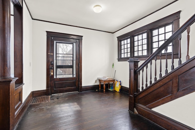 foyer entrance featuring ornamental molding, wood-type flooring, and stairs