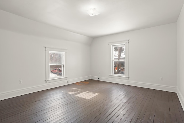 spare room with dark wood finished floors and baseboards