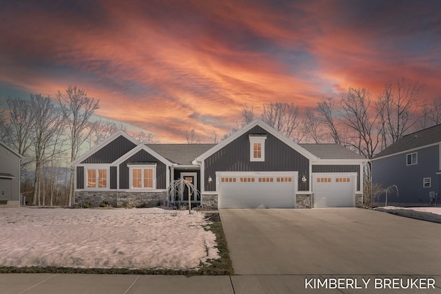 craftsman-style house featuring a garage, stone siding, board and batten siding, and concrete driveway