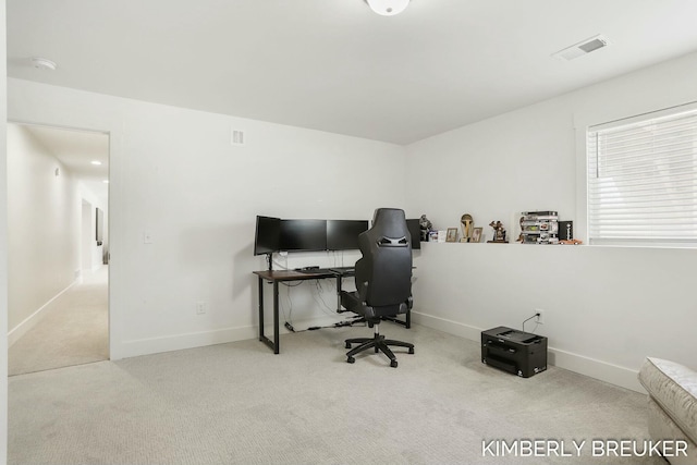 office space with baseboards, visible vents, and light colored carpet