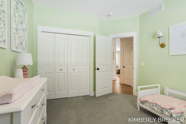 bedroom featuring a closet, visible vents, and dark carpet