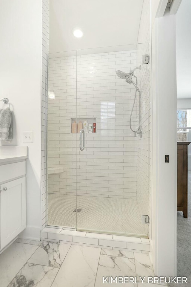 bathroom with marble finish floor, baseboards, vanity, and a shower stall