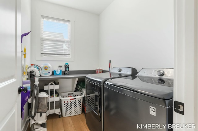 laundry area with laundry area, washer and clothes dryer, and wood finished floors