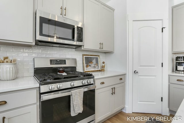 kitchen featuring appliances with stainless steel finishes, light countertops, and decorative backsplash