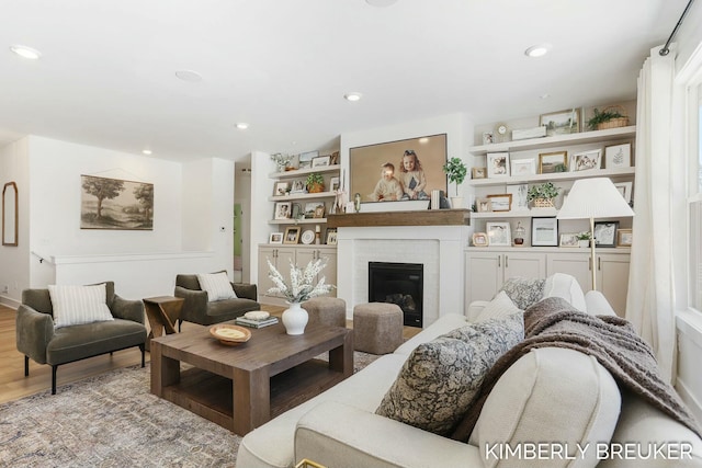 living room featuring recessed lighting, a fireplace, and light wood-style flooring