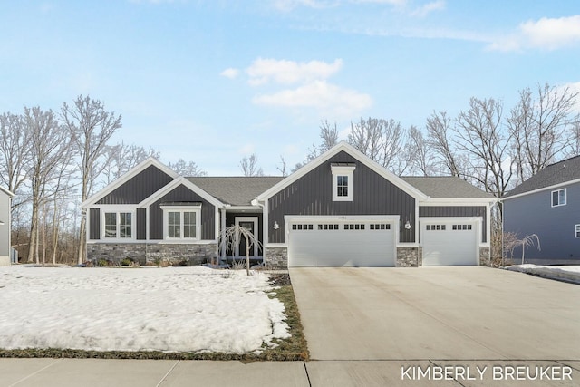 craftsman inspired home with a garage, stone siding, driveway, and board and batten siding