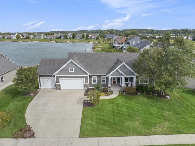 view of front of home with concrete driveway, stone siding, a residential view, a water view, and an attached garage