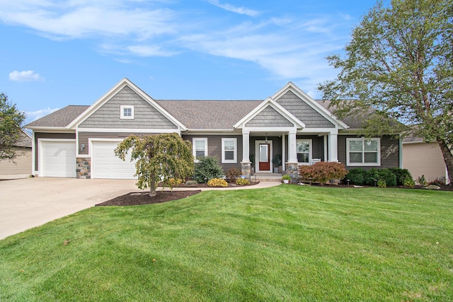 craftsman-style home featuring a garage, a front yard, stone siding, and driveway