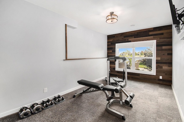 exercise room featuring wooden walls and baseboards