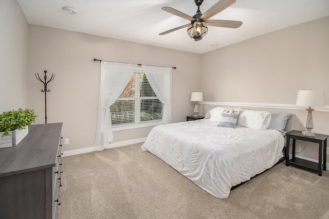 bedroom featuring a ceiling fan, light carpet, and baseboards