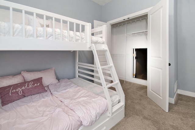 bedroom featuring a closet, light carpet, and baseboards