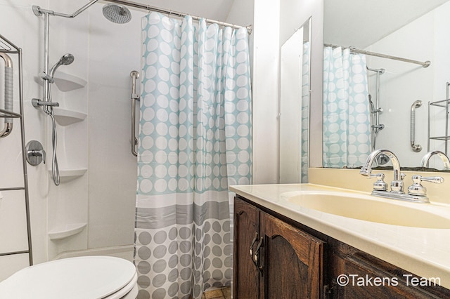 bathroom featuring toilet, a shower with shower curtain, and vanity