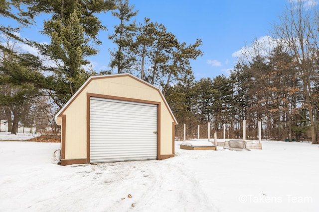 snow covered garage with a detached garage