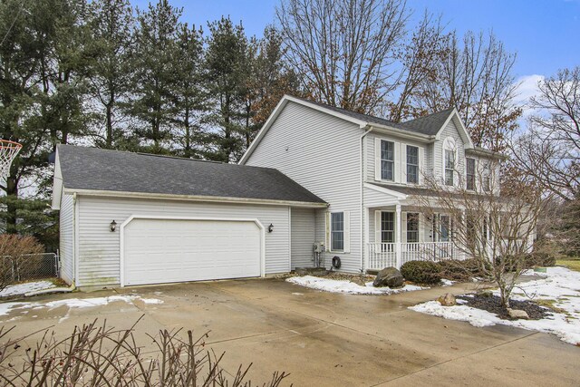 view of front of house featuring a garage, covered porch, concrete driveway, and roof with shingles