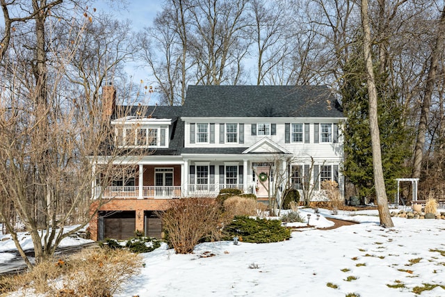 view of front facade featuring a garage, a chimney, and brick siding