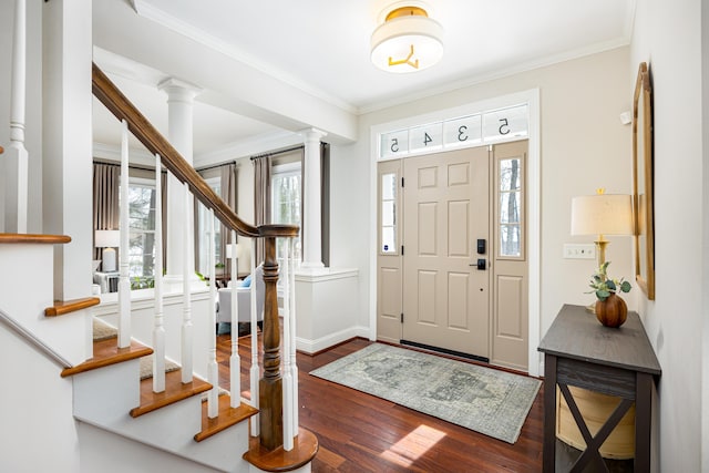 entryway with baseboards, ornamental molding, dark wood-type flooring, and ornate columns