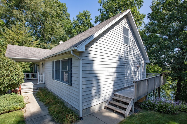 view of home's exterior featuring a deck and roof with shingles