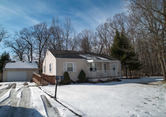 view of front of home featuring a detached garage, a porch, and an outbuilding