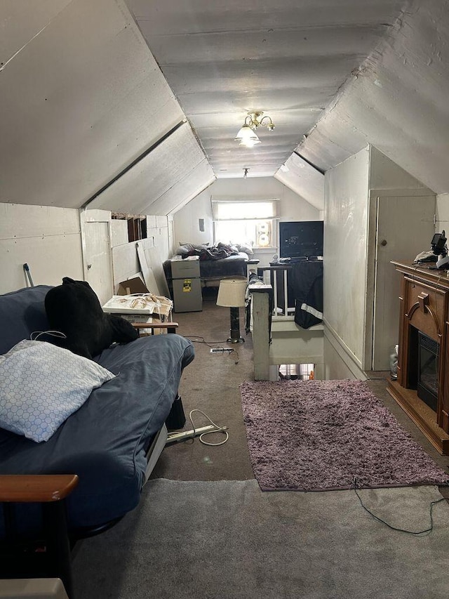 bedroom with carpet floors, lofted ceiling, and a fireplace