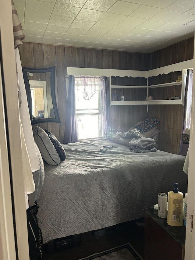 bedroom featuring wooden walls