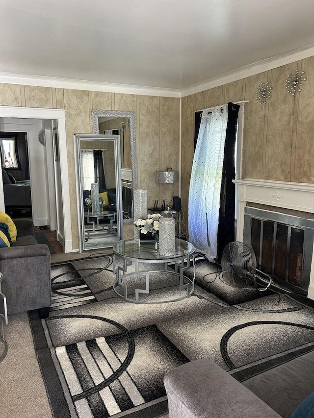 living area with crown molding and a glass covered fireplace